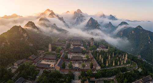 Vista aérea del monasterio de Shaolin nestled en las montañas Songshan con niebla matutina