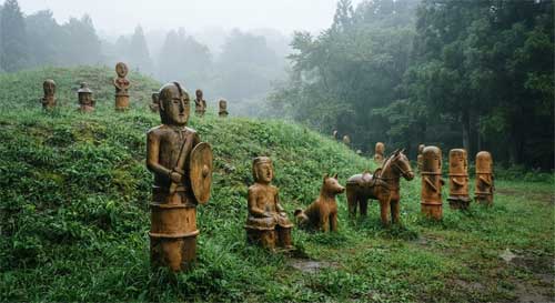 Figuras de terracota Haniwa dispuestas sobre un túmulo funerario bajo la lluvia