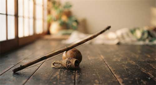 Berimbau y caxixi sobre madera envejecida simbolizando la capoeira como resistencia cultural