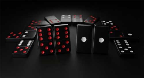 Fichas de dominó chino apiladas mostrando puntos rojos y blancos sobre fondo negro