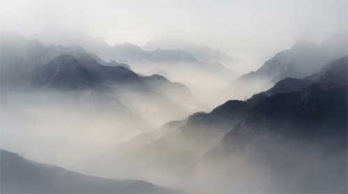Paisaje etéreo de montañas disolviéndose en niebla matinal, luz suave difusa sin fuente visible, atmósfera de vacuidad luminosa y paz absoluta