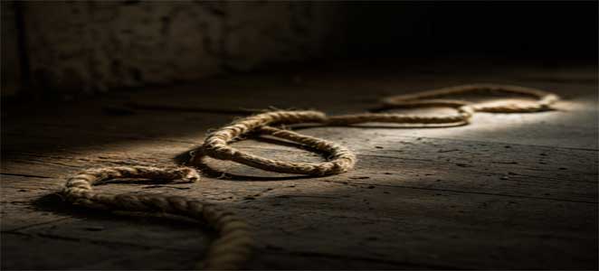 La ilusión del miedo Una cuerda enrollada en el suelo bajo una luz tenue, sugiriendo la forma de una serpiente