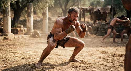 Practicante de artes marciales antiguas en una postura de combate dinámica y agresiva