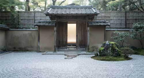 Puerta tradicional japonesa de madera abierta hacia un jardín zen minimalista