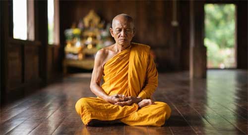 Monje birmano en meditación intensa con los ojos entreabiertos, enfocando la atención en el movimiento sutil del abdomen, simbolizando el método Mahasi