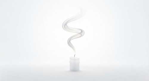 Una llama de vela apagándose suavemente dejando una espiral de humo blanco que se disuelve en un espacio luminoso y vacío