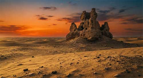 Ruinas antiguas de una estupa budista de adobe en el desierto de Taklamakán, con muros erosionados por el viento bajo un cielo anaranjado del atardecer