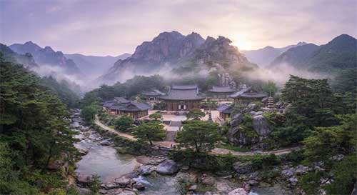 Templo coreano integrado perfectamente en un valle montañoso según principios de pungsu-jiri, con corrientes de agua y bosques que fluyen alrededor de la arquitectura tradicional