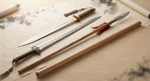 Composición artística de cuatro armas tradicionales chinas: una espada recta, un sable curvo, una lanza con borla y un bastón largo, dispuestas elegantemente