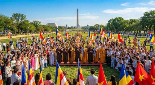 Gran celebración al aire libre con monjes vietnamitas y devotos frente a un templo de arquitectura tradicional, con banderas de loto y el Capitolio de fondo simbólico