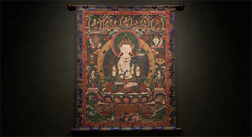 Pintura Thangka nepalí antigua, composición simétrica, colores rojos intensos y azules profundos, figura central de deidad benigna